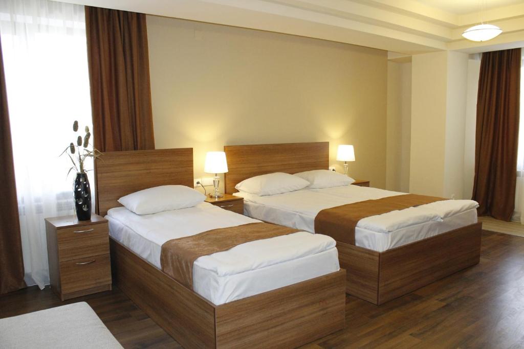 Habitación de hotel con 2 camas y 2 lámparas en 5th Floor Guest House Yerevan, en Ereván
