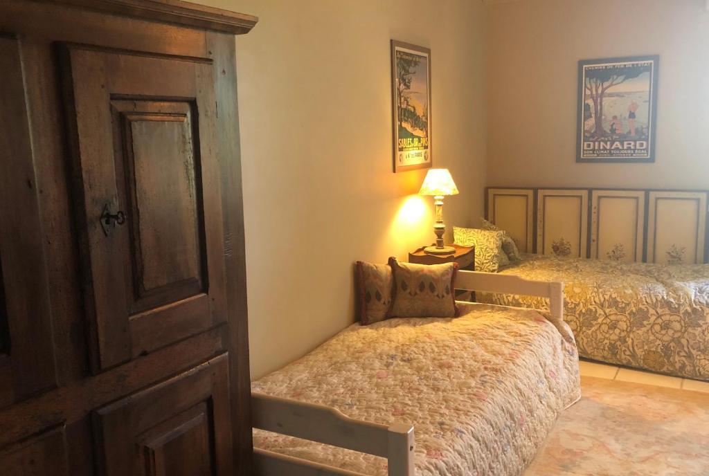 a bedroom with two beds and a door and a lamp at Maison Lamothe in Flamarens