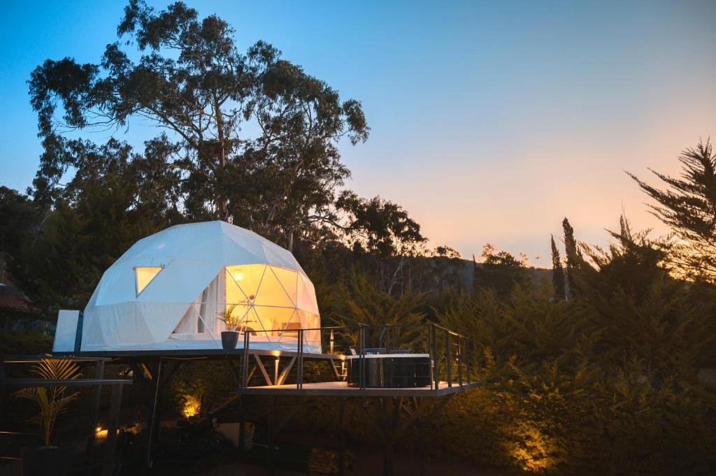 une tente en forme de dôme sur une terrasse au coucher du soleil dans l'établissement Samaipata Glamping, à Samaipata