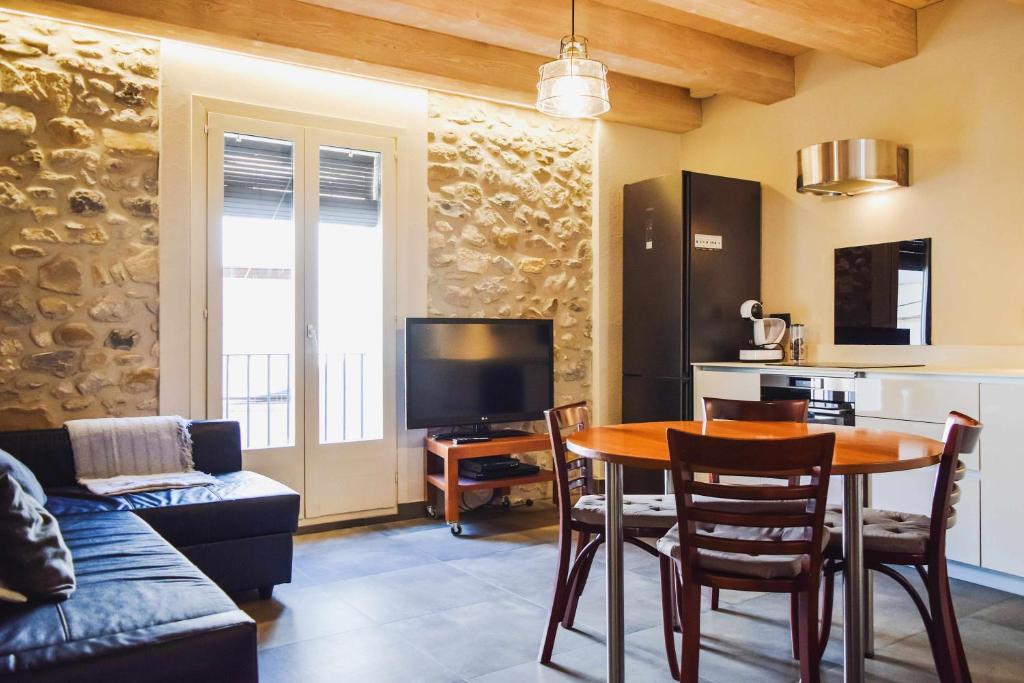 a living room with a table and a kitchen at El Call, LEstudi en la judería de Besalú in Besalú
