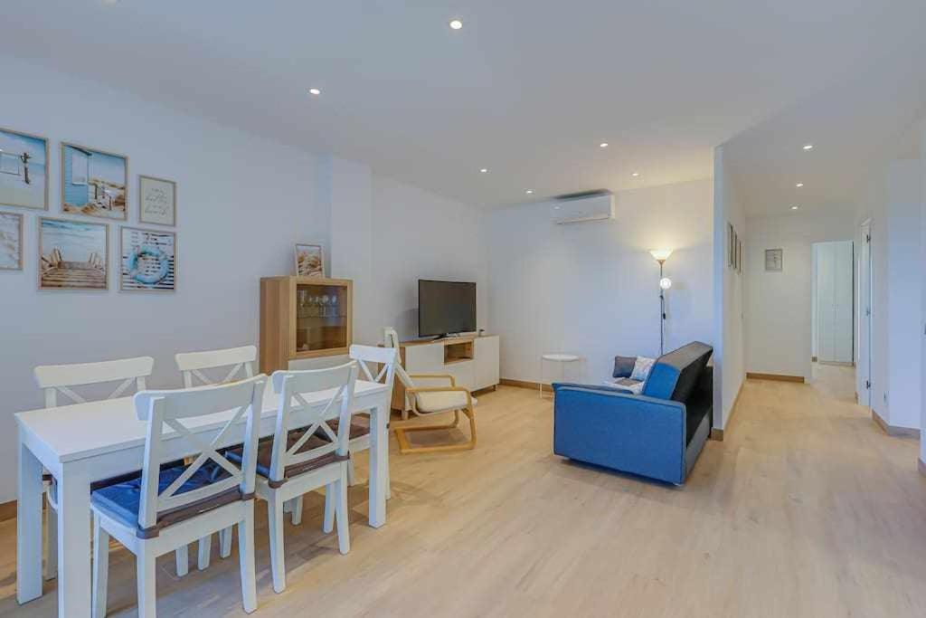 a living room with a table and chairs and a couch at Apartamento Condal in Blanes