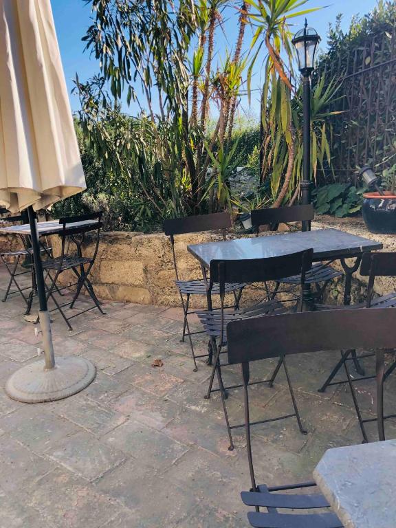 a patio with a table and chairs and an umbrella at Au bout du pré in Pézenas