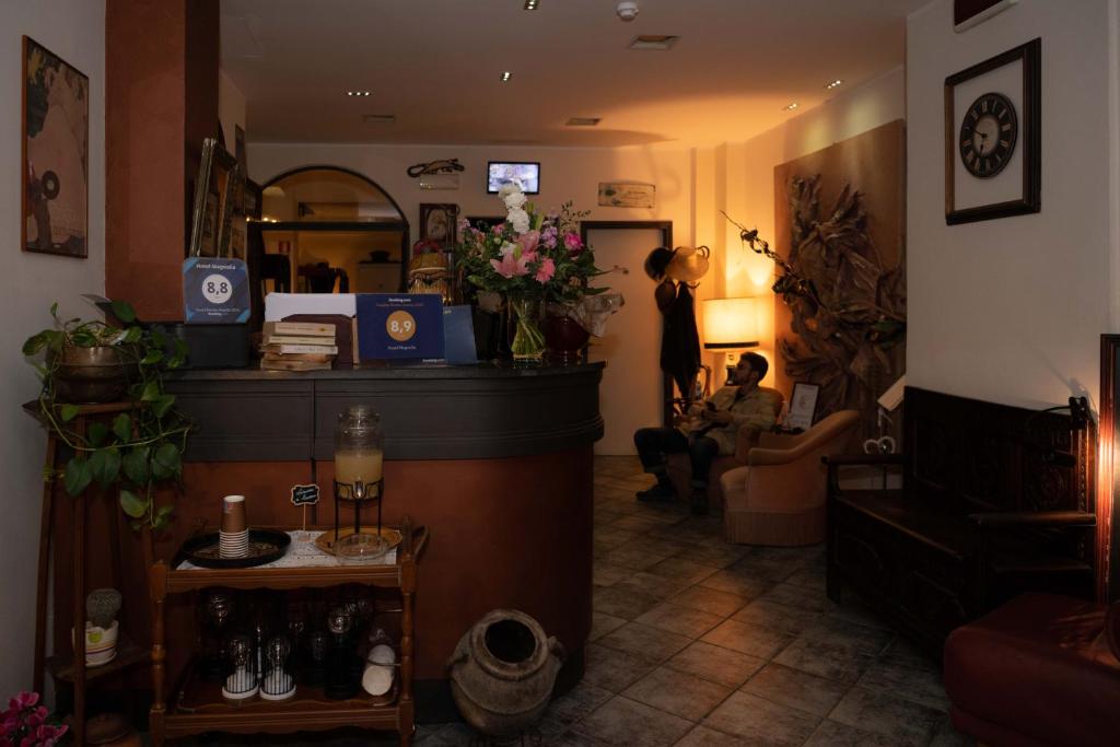 Una donna seduta in una sala d'attesa in un salone di Hotel Magnolia ad Albenga