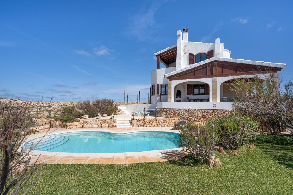 a house with a swimming pool in front of it at Binizzy in Cala Morell