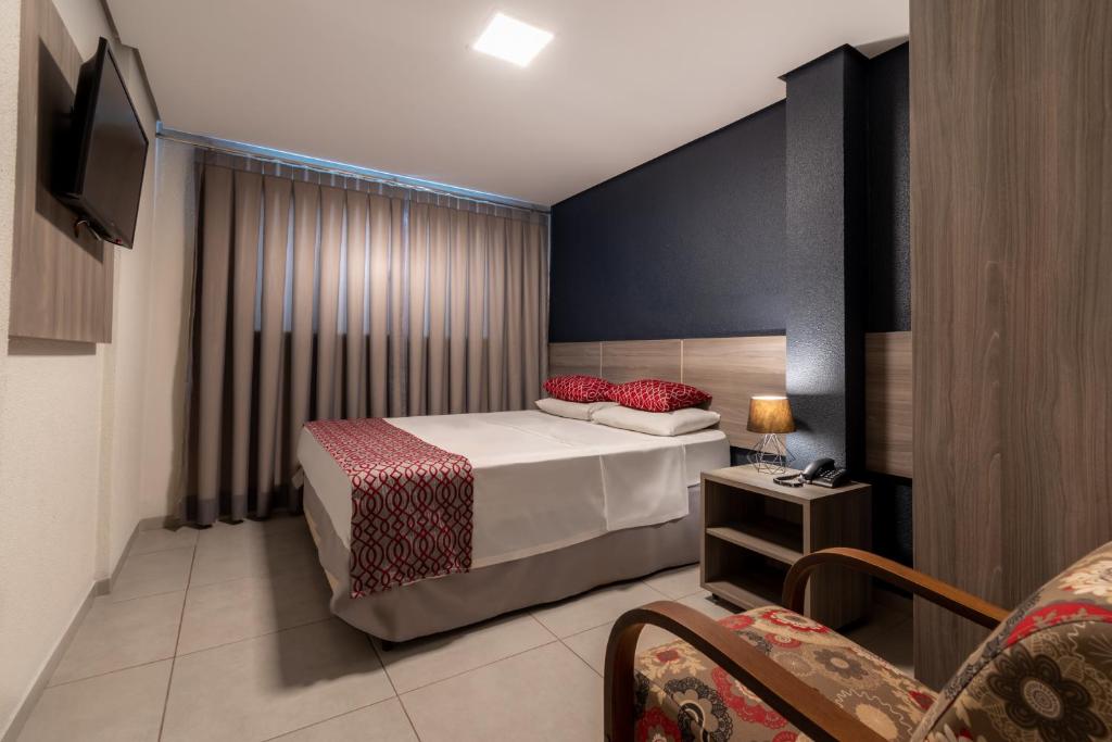 pokój hotelowy z łóżkiem i telewizorem w obiekcie 103 Hotel & Flats w mieście Palmas