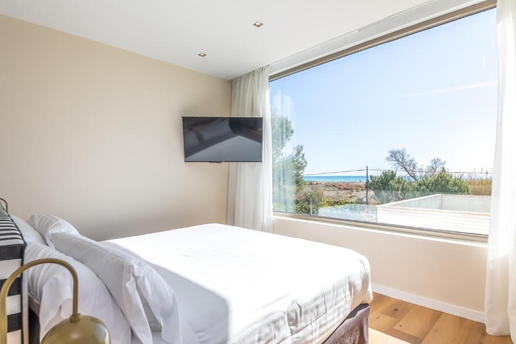 a bedroom with a bed and a large window at Hotel Barú in Sagunto