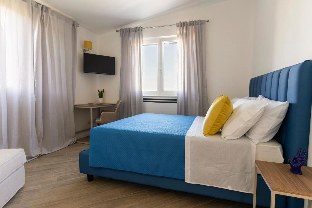 1 dormitorio con cama azul y almohada amarilla en Tenuta Di Leva, en Piano di Sorrento