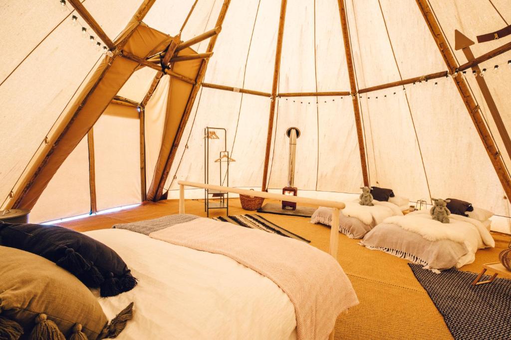 een kamer met drie bedden in een tent bij GreenWood Family Park in Y Felinheli