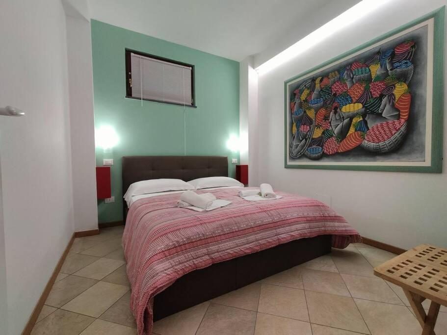 1 dormitorio con 1 cama grande y una pintura en la pared en Il Bassotto - Homy 5 Terre, en Volastra