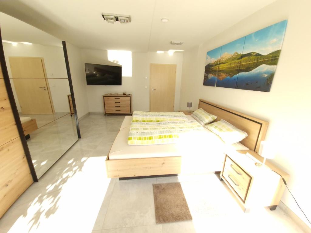 une chambre avec un grand lit et une télévision dans l'établissement Ferienwohnung Jehl, à Aying