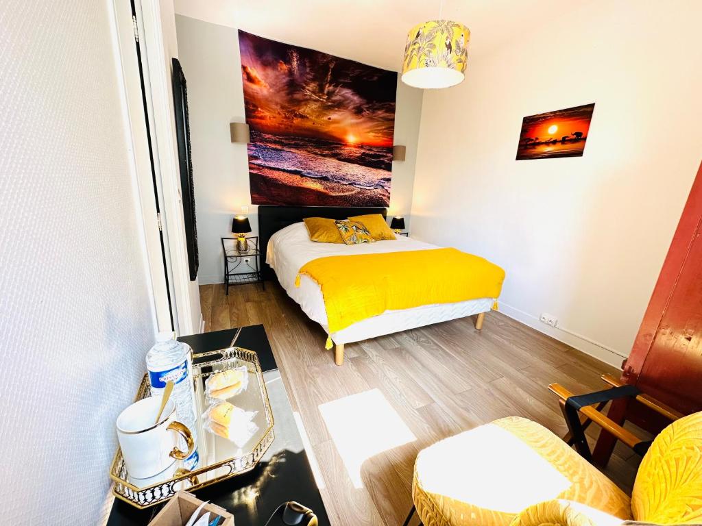 a bedroom with a bed with a yellow blanket at Manoir de la Marjolaine in Cabourg