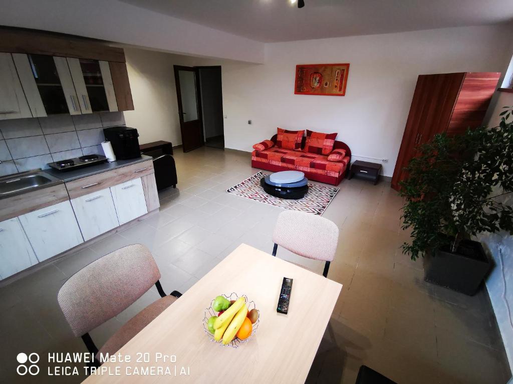 a living room with a table and a red couch at Cluj City Marasti Apartament 1 in Cluj-Napoca