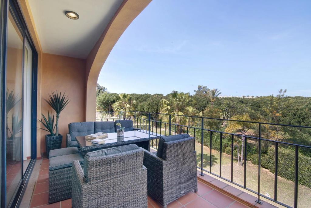 Un balcón con sillas de mimbre y una mesa en un balcón. en Apartamento T2 Vilasol Morgadinho, en Vilamoura