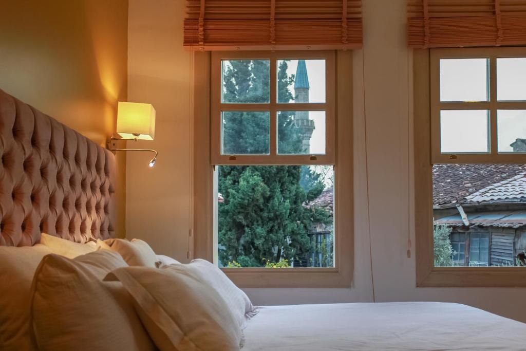a bedroom with a bed and three windows at Exceptional Studio Flat near Hadrian&#39;s Gate in Antalya