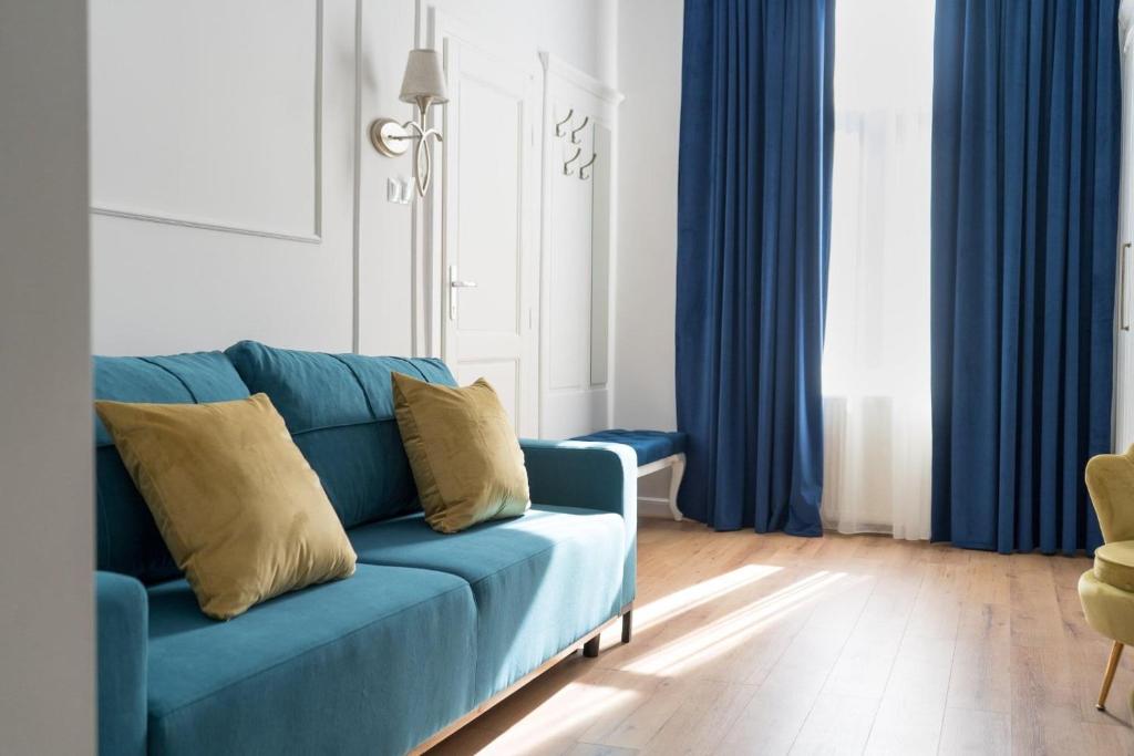 a blue couch in a living room with blue curtains at Pensiunea Korona and Restaurant in Miercurea-Ciuc