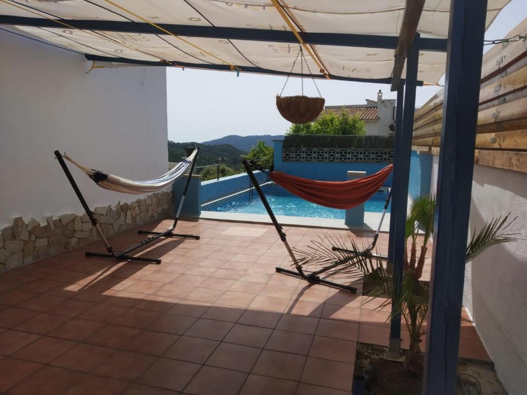 a patio with a hammock and a swimming pool at Cosy House Near Beach in Lloret de Mar
