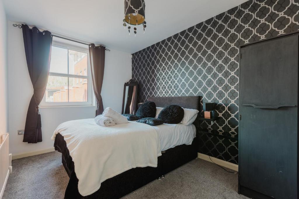 a bedroom with a bed and a large window at Hullidays - Theatre Side Apartment - Refurbished 2023 in Hull