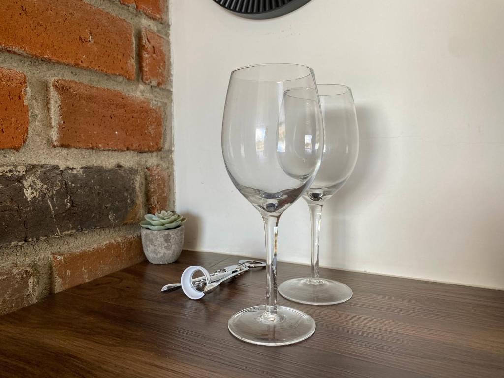 two wine glasses sitting on top of a wooden table at Palta 60 Valle de Guadalupe in Valle de Guadalupe