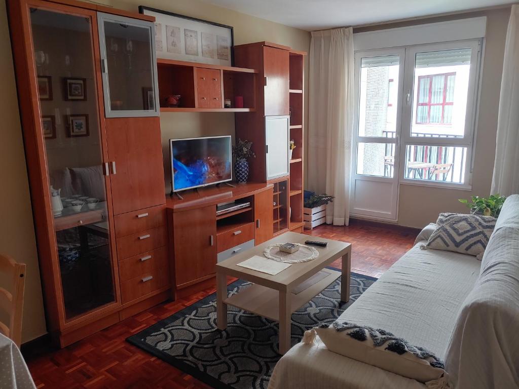 ein Wohnzimmer mit einem Sofa und einem Tisch in der Unterkunft Cuenca 3 in Gijón