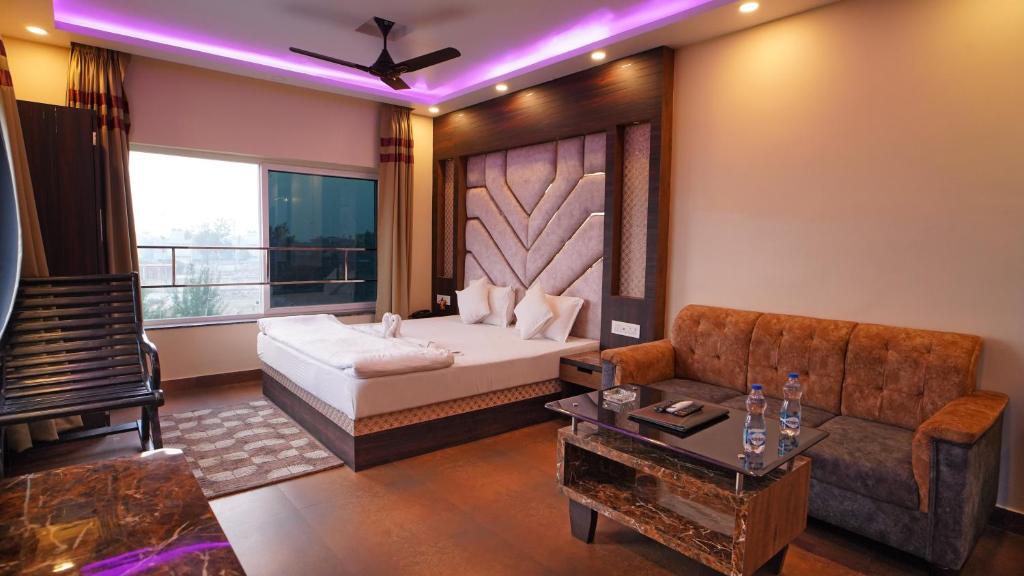 Un dormitorio con una cama, un sofá y una mesa. en Sher Bengal Beach Resort, en Mandarmani