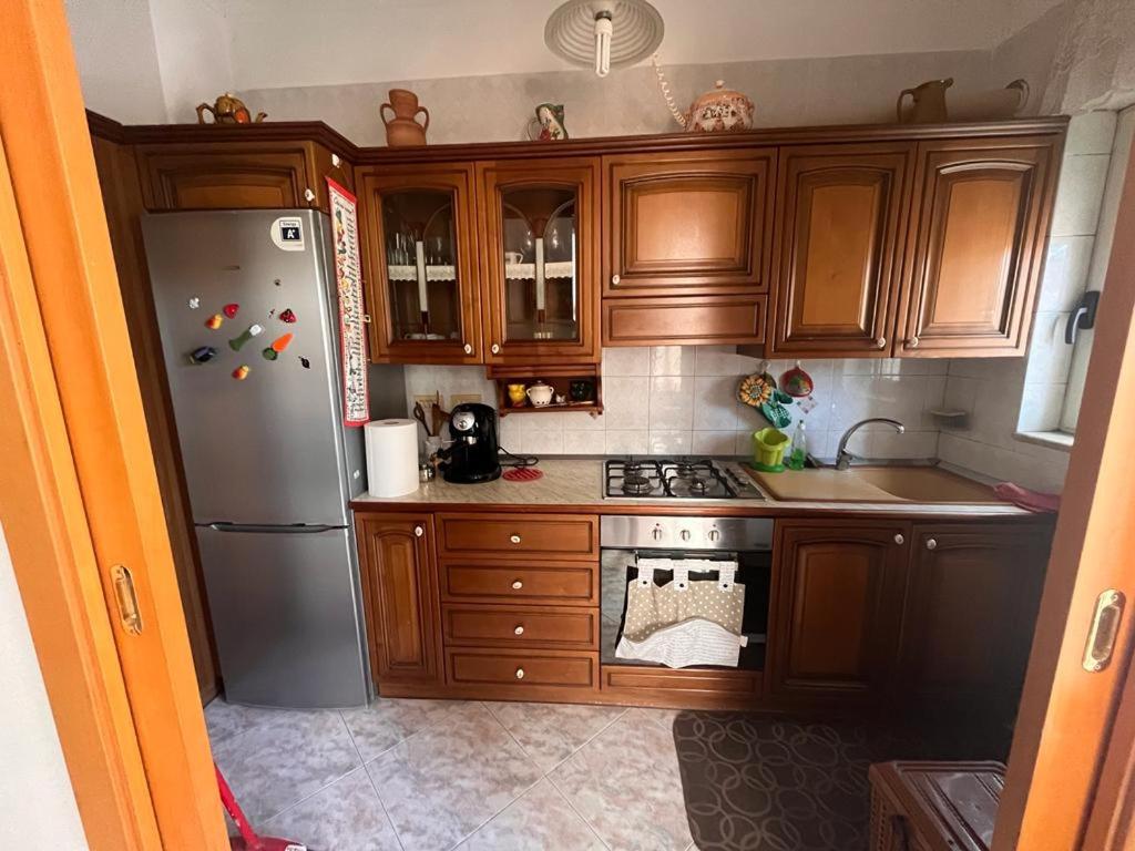 uma cozinha com armários de madeira e um frigorífico em Casa Anna em Pomarico