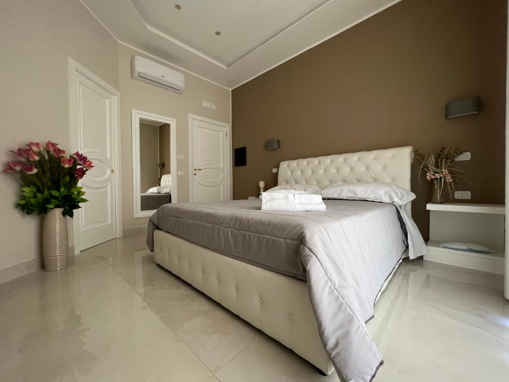 a bedroom with a large bed with a white headboard at Pompei via Roma Suite in Pompei