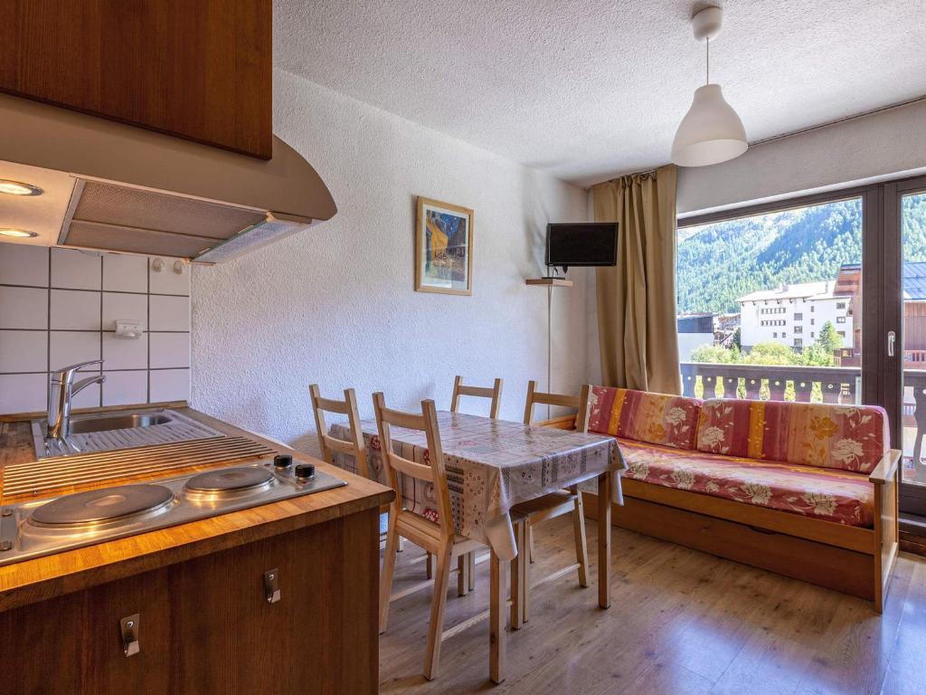- une cuisine et une salle à manger avec une table et un canapé dans l'établissement Studio cosy proche des pistes, balcon Sud/Est, navette, local à skis – Val-d'Isère - FR-1-694-86, à Val dʼIsère