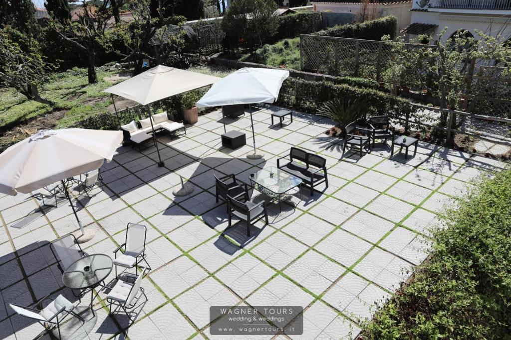 a patio with tables and chairs and umbrellas at Ravello 23 Accommodation in Ravello