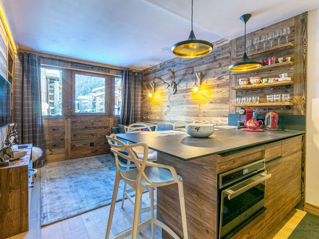 - une cuisine avec des murs en bois, une table et des chaises dans l'établissement Appartement de prestige au pied des pistes avec wifi, parking couvert, et balcon exposé Est - FR-1-694-153, à Val dʼIsère
