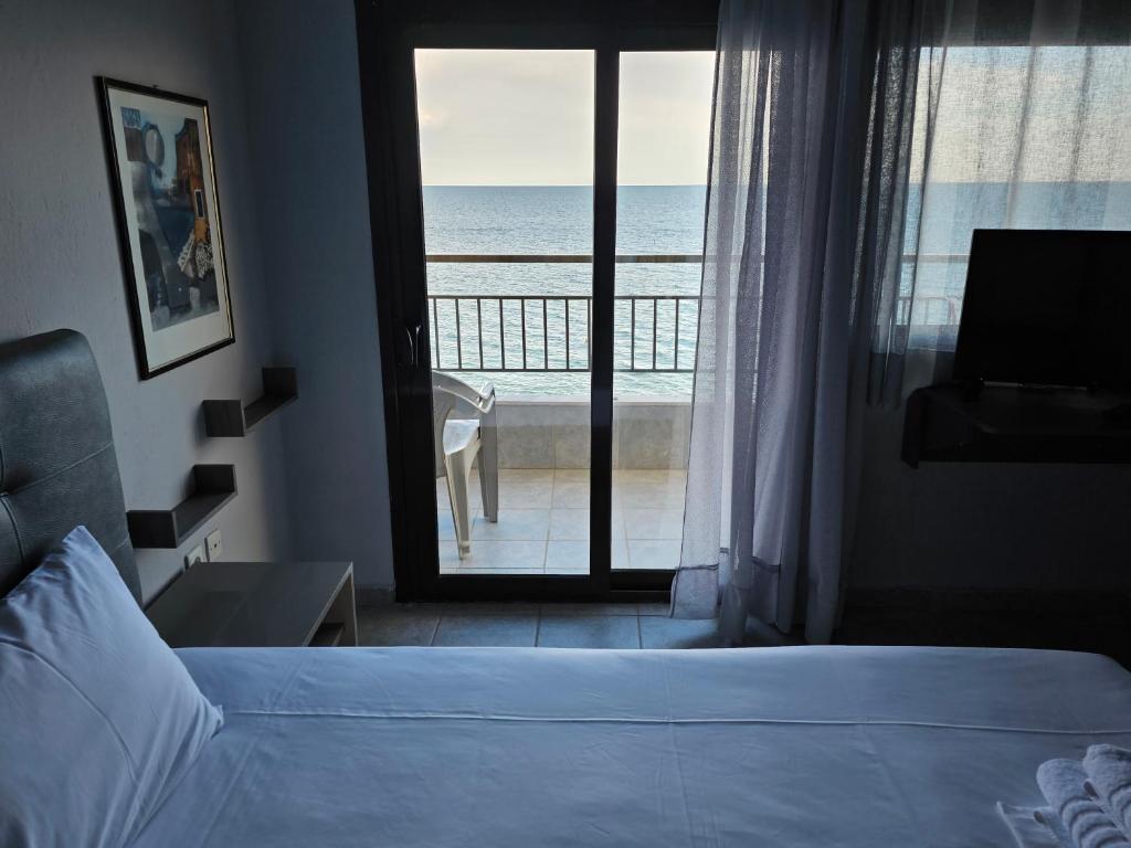 a bedroom with a bed and a view of the ocean at Studio Just On The Beach in Paralia Katerinis