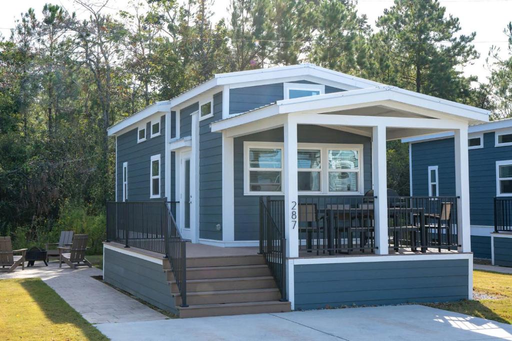 a blue house with a porch and a deck at Sun Outdoors New Orleans North Shore in Robert