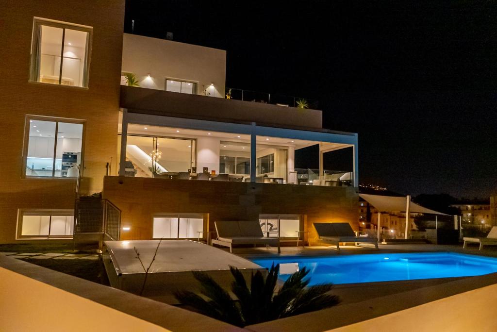una casa con piscina por la noche en Villa Palm Beach - Incredible villa with 5 rooms, amazing sea view and private pool, en Fuengirola