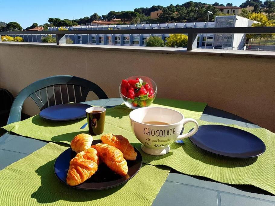 uma mesa com um prato de croissants e uma chávena de café em Maravilloso piso con piscina a 200m de la playa em Lloret de Mar