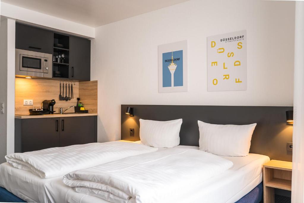 2 camas en una habitación pequeña con cocina en Apartments an der Kö en Düsseldorf