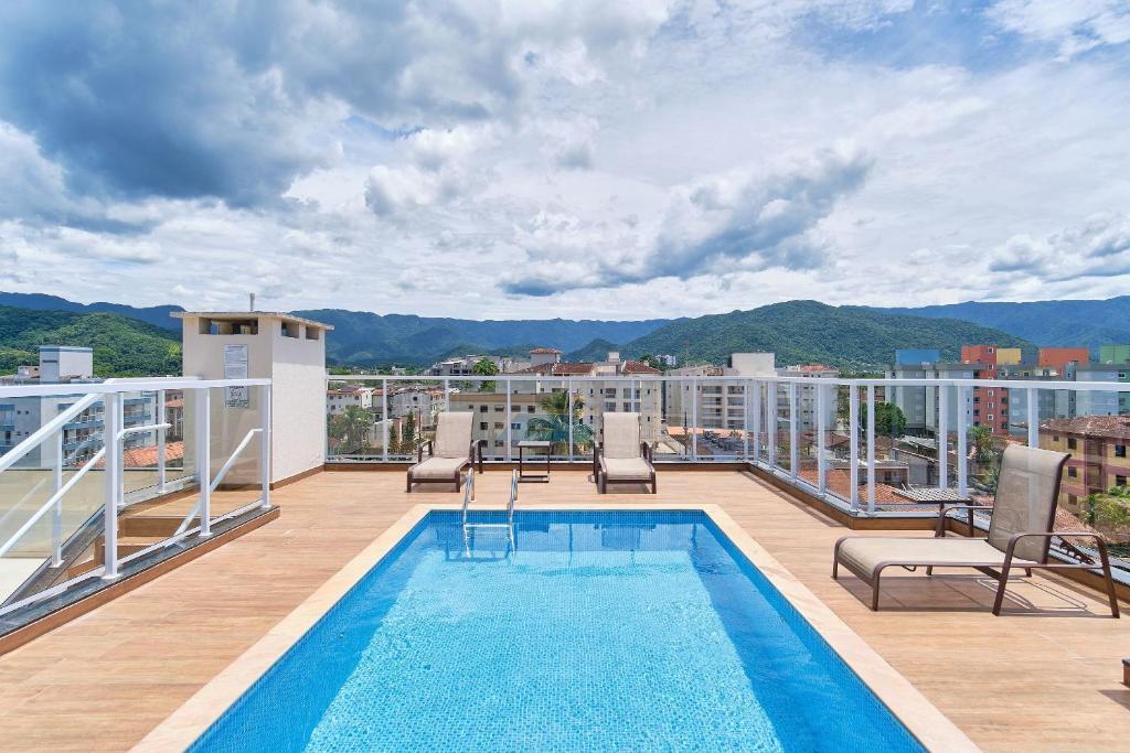 a balcony with a swimming pool on top of a building at 500 metros da Orla Itaguá em Ubatuba - Varanda Gourmet/ Wi-fi in Ubatuba