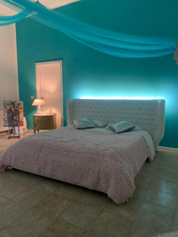 una camera con un grande letto con una parete blu di Alla Casetta B&B Relax a San Felice a Cancello