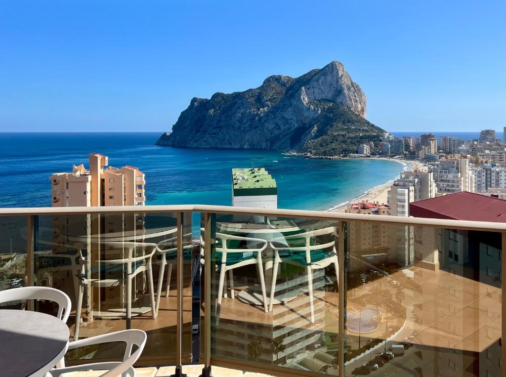 een balkon met stoelen en uitzicht op de oceaan bij Esmeralda Suites 21º piso in Calpe