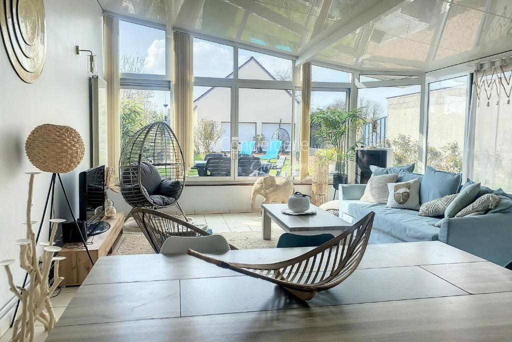 uma sala de estar com duas cadeiras e um sofá em FM42 - À Ciel Ouvert Maison avec grande veranda et jardin em Friaucourt