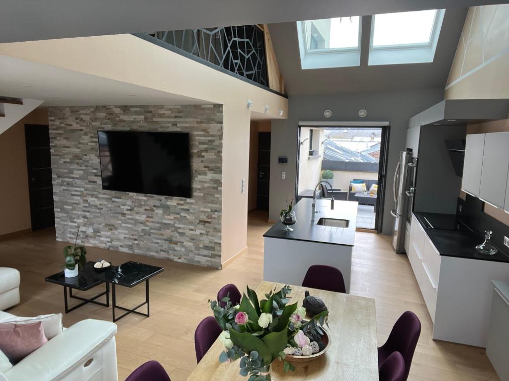 cocina y sala de estar con pared de piedra en Appartement le penthouse, Villa Les Bains De Mers en Mers-les-Bains
