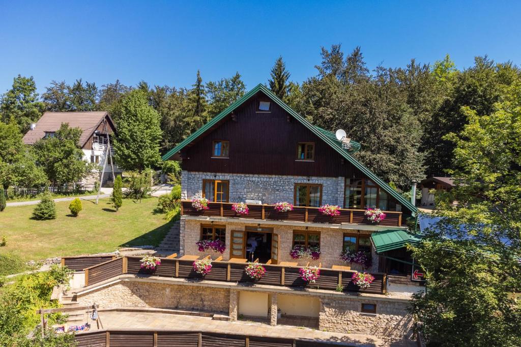 a house with flowers on the balcony of it at Golden Lakes Rooms in Plitvička Jezera