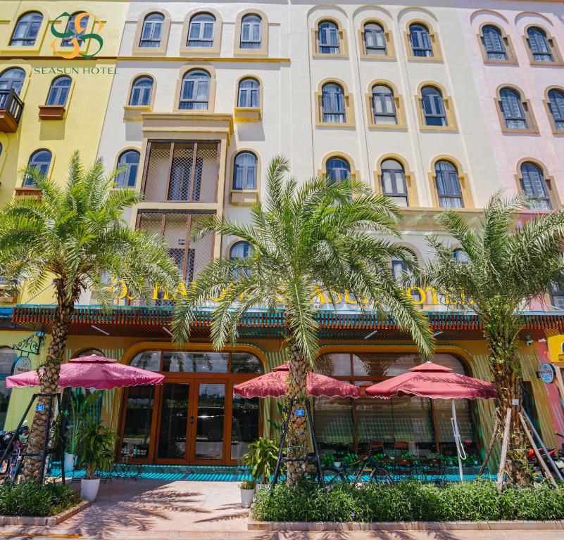 下龍灣的住宿－Ha Long Seasun Hotel，棕榈树和粉红色遮阳伞的酒店
