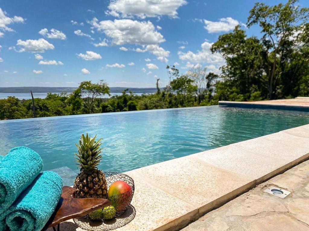 un bol de fruta sentado junto a una piscina en Mansion a Lago, en Itauguá