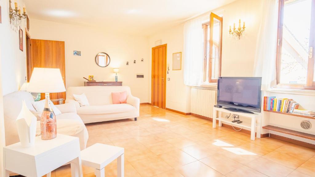 a living room with a white couch and a tv at In the Heart of Reinessance - Italian Homing in Solferino