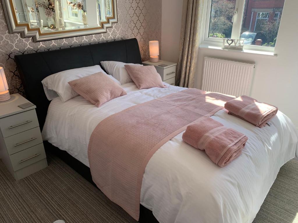 a bedroom with a large bed with two pillows on it at Kensington Luxury Apartment on Gated Development in Leafy edge of Chorley Town Centre in Chorley