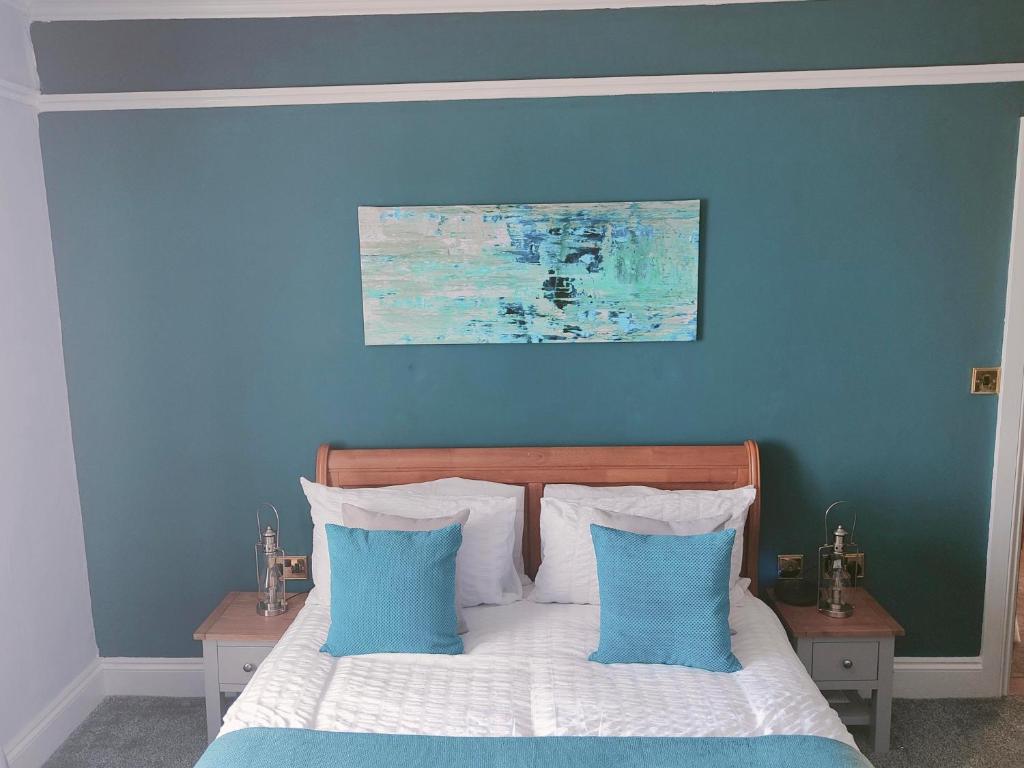 a blue bedroom with a bed with two blue pillows at The Dial inn in Lamphey