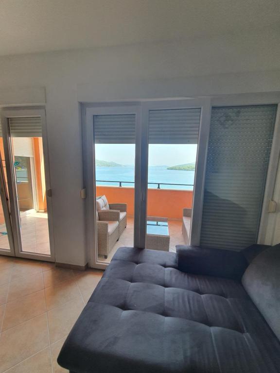 sala de estar con sofá y vistas al océano en Apartman Monika, en Marina