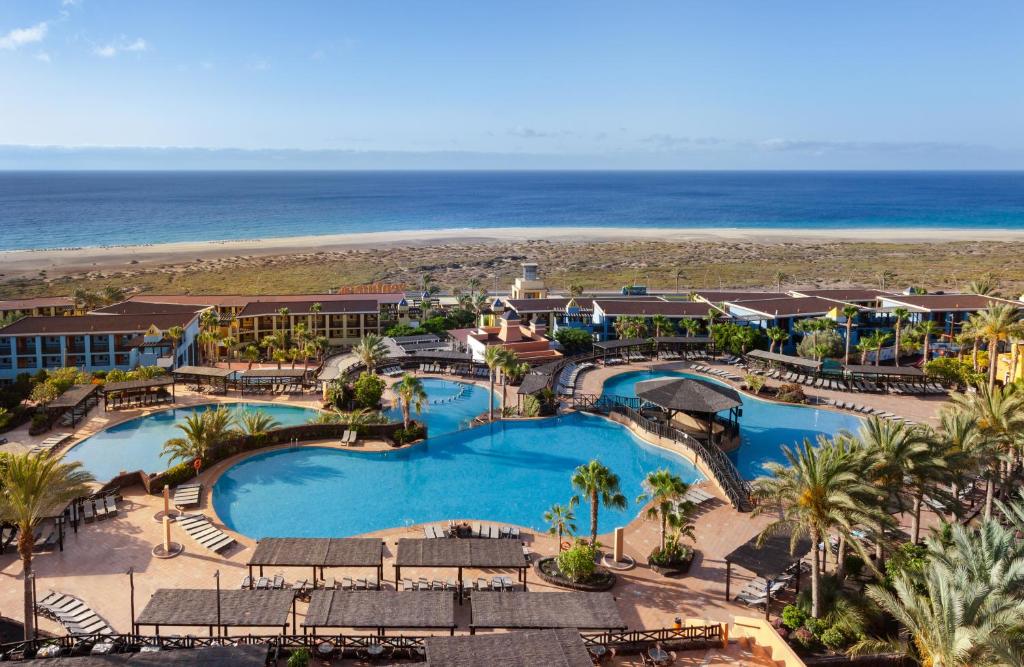 an aerial view of a resort with a pool and the beach at Occidental Jandía Playa in Morro del Jable