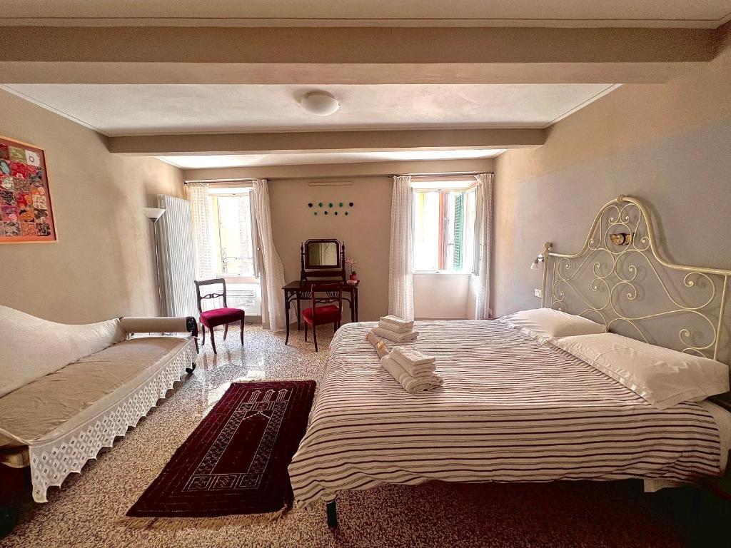 - une grande chambre avec 2 lits et une table dans l'établissement Casa Albertina, à Lucques