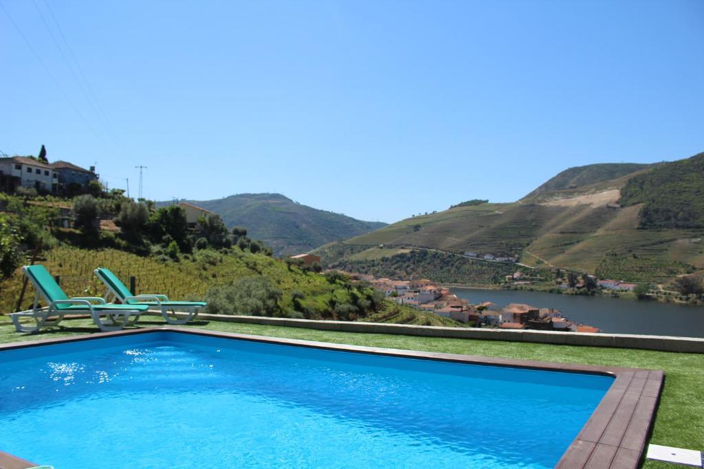 a swimming pool with a view of a river and mountains at Casa José Lourenço in Folgosa