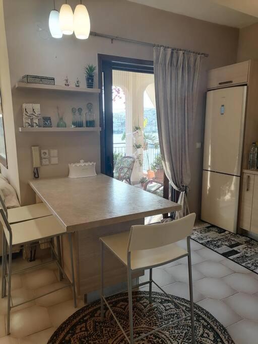 a kitchen with a table and chairs and a refrigerator at SuiteViewPoros-Luxury Apartment in Galatas in Galatas